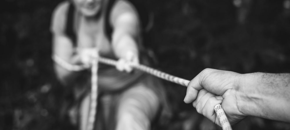 Woman climbing up a rope