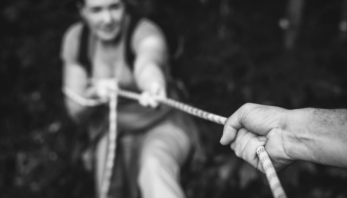 Woman climbing up a rope